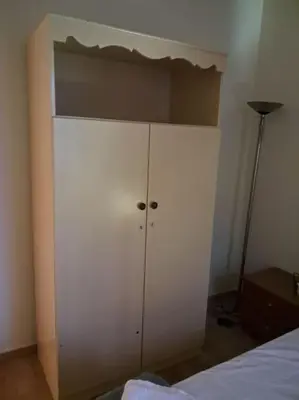 a white cabinet in a bedroom with a bed at West Athens Welcome Δυτικά της Αθήνας in Athens