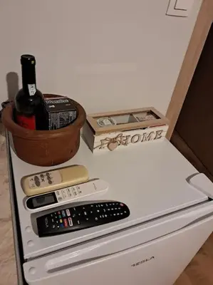 a bottle of wine sitting on top of a refrigerator at West Athens Welcome Δυτικά της Αθήνας in Athens