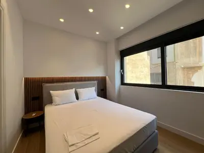 a bedroom with a large bed with a window at BlueMotion - CruiseNest Complex in Piraeus