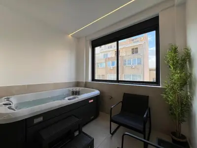 a bathroom with a tub and a chair and a window at BlueMotion - CruiseNest Complex in Piraeus