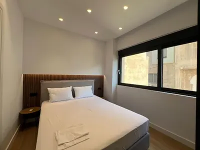 a bedroom with a large bed and a window at BlueMotion - CruiseNest Complex in Piraeus