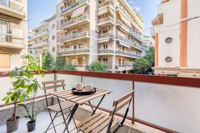 a table and chairs on a balcony with a building at Secret Central Gem Near Kolonaki in Athens