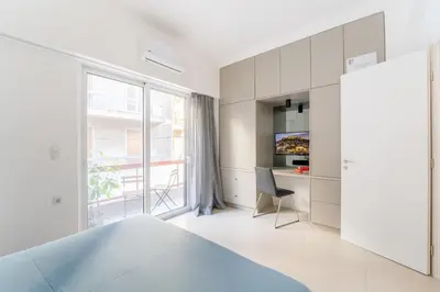 a white bedroom with a bed and a desk at Secret Central Gem Near Kolonaki in Athens