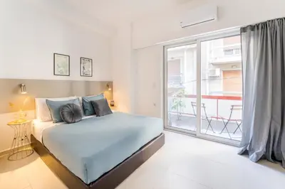 a bedroom with a bed and a large window at Secret Central Gem Near Kolonaki in Athens