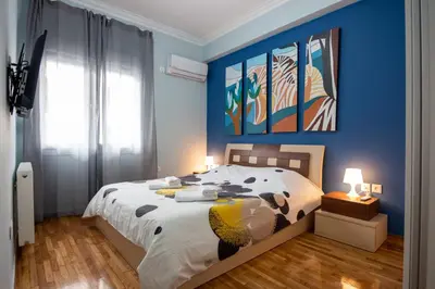 a bedroom with a large bed with a blue wall at Nice Apartment in Athens center in Athens