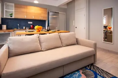 a couch in a living room with a kitchen at Nice Apartment in Athens center in Athens