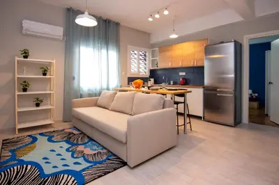 a living room with a couch and a kitchen at Nice Apartment in Athens center in Athens