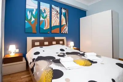 a bedroom with a large bed with a cow blanket at Nice Apartment in Athens center in Athens