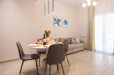 a living room with a table and chairs and a couch at Apartment near Onassis cultural center in Athens