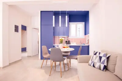 a kitchen and living room with a table and chairs at Apartment near Onassis cultural center in Athens