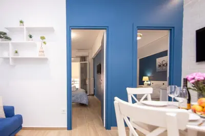 a living room with a blue wall and a table and chairs at Sweet 2 bedroom apartment in Greek colors in Athens