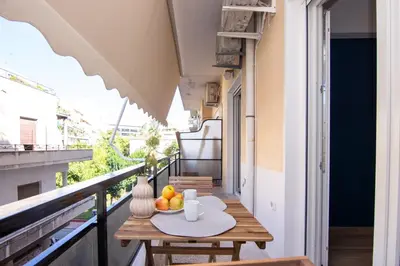 a table on a balcony with a bowl of fruit at Sweet 2 bedroom apartment in Greek colors in Athens