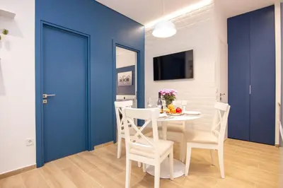 a dining room with blue walls and a table and chairs at Sweet 2 bedroom apartment in Greek colors in Athens