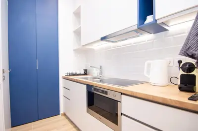 a kitchen with white cabinets and a blue door at Sweet 2 bedroom apartment in Greek colors in Athens