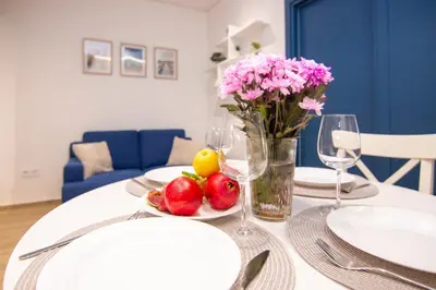 a table with a plate of fruit and a vase of flowers at Sweet 2 bedroom apartment in Greek colors in Athens