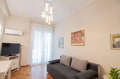 a living room with a couch and a tv at Work of Art Athens in Athens