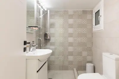 a white bathroom with a sink and a toilet at Athens Acropolis Residence, by the Acropolis Museum in Athens