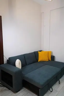 a living room with a blue couch and a tv at Athenian Petralona Suite near Athens City centre in Athens