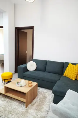 a living room with a blue couch and a coffee table at Athenian Petralona Suite near Athens City centre in Athens