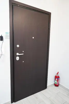 a wooden door in a room with a fire extinguisher at Athenian Petralona Suite near Athens City centre in Athens