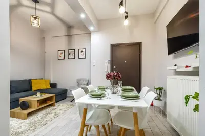 a living room with a white table and chairs at Athenian Petralona Suite near Athens City centre in Athens