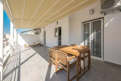 a patio with a wooden table and chairs on a balcony at Spacious Athens Apt Large Balcony 200m to Metro in Athens