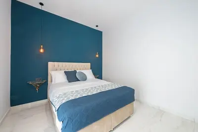 a bedroom with a bed with a blue wall at Spacious Athens Apt Large Balcony 200m to Metro in Athens