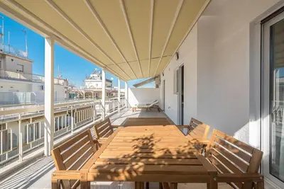 a wooden table on a balcony with two benches at Spacious Athens Apt Large Balcony 200m to Metro in Athens