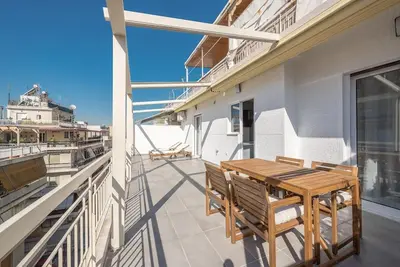 a patio with a wooden table and chairs on a balcony at Spacious Athens Apt Large Balcony 200m to Metro in Athens