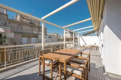 a wooden table and chairs on the balcony of a building at Spacious Athens Apt Large Balcony 200m to Metro in Athens
