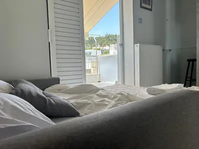 a bed in a room with a large window at Cozy apartment in lycabettus hills in Athens