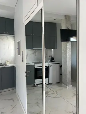 a kitchen with black and white cabinets and a door at Cozy apartment in lycabettus hills in Athens