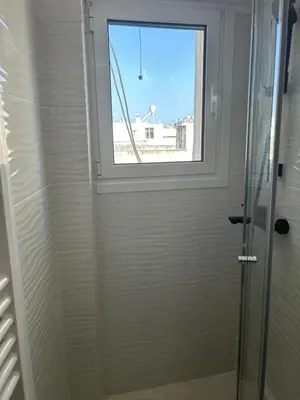 a bathroom with a shower with a window at Cozy apartment in lycabettus hills in Athens