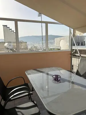 a glass table and chairs in a room with a window at Cozy apartment in lycabettus hills in Athens