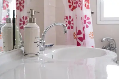 a bathroom sink with a bottle of soap on it at Family home in Lagonisi in Lagonissi