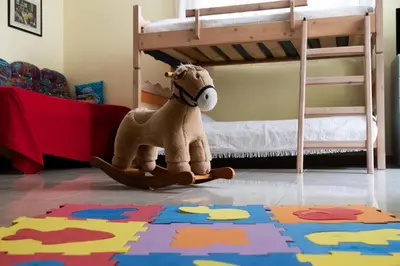 a stuffed horse sitting on a rug in a bedroom at Family home in Lagonisi in Lagonissi
