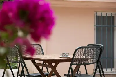 a wooden table and chairs with a cup on top at Family home in Lagonisi in Lagonissi