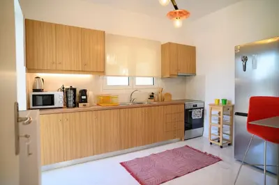 a kitchen with wooden cabinets and a stainless steel refrigerator at Seclusion, Privacy and 2 bedroom Luxury in Glyfada in Athens