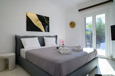 a bedroom with a large bed with towels on it at Seclusion, Privacy and 2 bedroom Luxury in Glyfada in Athens