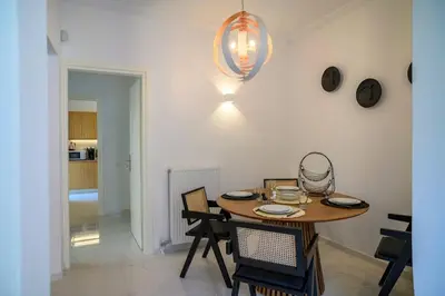 a dining room with a wooden table and chairs at Seclusion, Privacy and 2 bedroom Luxury in Glyfada in Athens