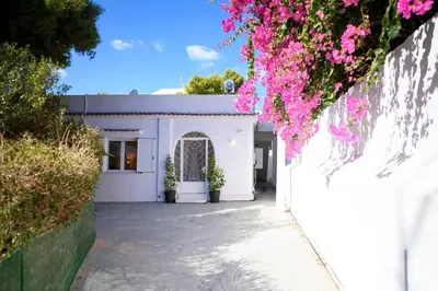 a white building with pink flowers hanging from it at Seclusion, Privacy and 2 bedroom Luxury in Glyfada in Athens