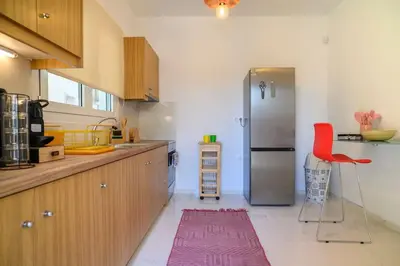 a kitchen with a refrigerator and a red chair in it at Seclusion, Privacy and 2 bedroom Luxury in Glyfada in Athens