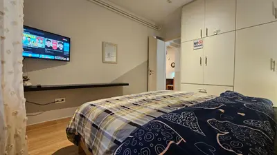 a room with a bed and a flat screen tv at Όμορφο ημιυπόγειο διαμέρισμα στην Αθήνα με αυλή in Athens