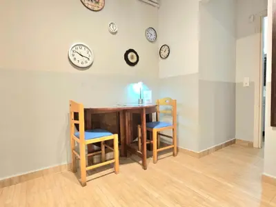 a room with a table and chairs and clocks on the wall at Όμορφο ημιυπόγειο διαμέρισμα στην Αθήνα με αυλή in Athens