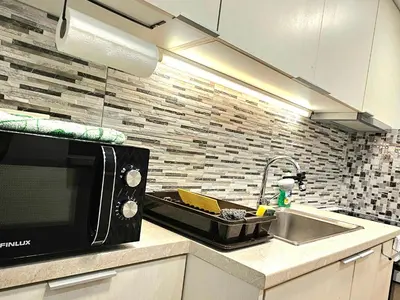 a kitchen with a sink and a microwave at Όμορφο ημιυπόγειο διαμέρισμα στην Αθήνα με αυλή in Athens
