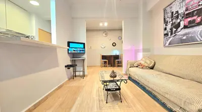a living room with a couch and a table at Όμορφο ημιυπόγειο διαμέρισμα στην Αθήνα με αυλή in Athens