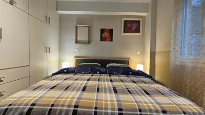 a bedroom with a bed with a plaid at Όμορφο ημιυπόγειο διαμέρισμα στην Αθήνα με αυλή in Athens