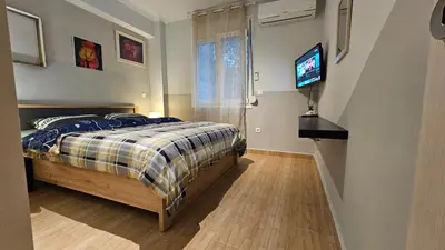 a bedroom with a bed and a flat screen tv at Όμορφο ημιυπόγειο διαμέρισμα στην Αθήνα με αυλή in Athens