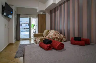 a living room with two red pillows on a bed at Premium Athenian District Urban Studio in Athens