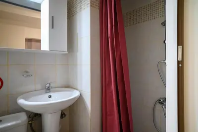 a bathroom with a sink and a red shower curtain at Premium Athenian District Urban Studio in Athens